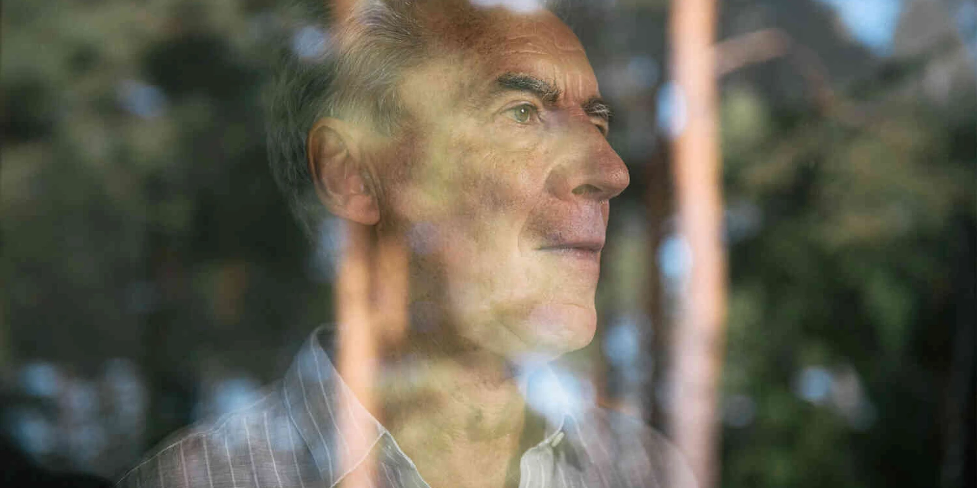 Mann schaut aus dem Fenster