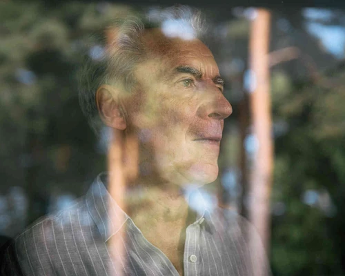 Mann schaut aus dem Fenster