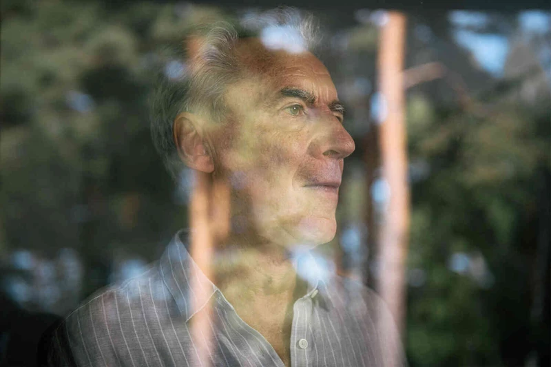 Mann schaut aus dem Fenster