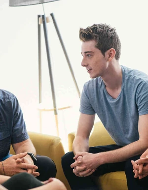 Junger mann sitzt in einer erwachsenen gruppe