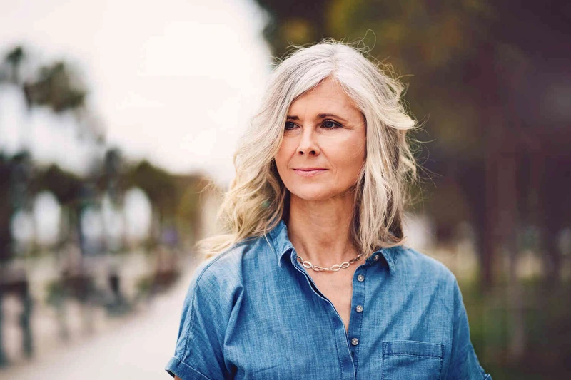 Frau steht draue&szlig;n und schaut in die Ferne