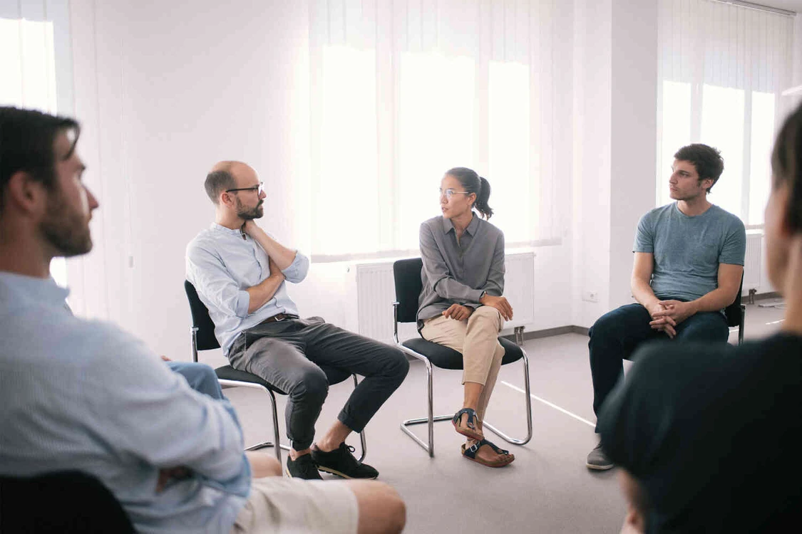 Eine Gruppe von Menschen in einem wei&szlig;en Therapie Raum