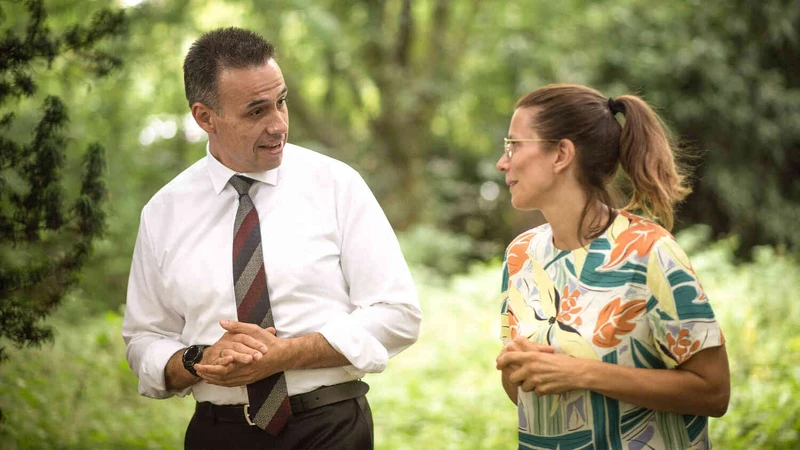 Zwei Personen spazieren drau&szlig;en und unterhalten sich.